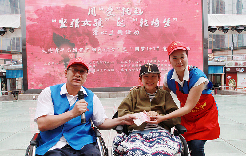 韩伟（左一）与爱人陶陆帮助重度残疾人实现“轮椅梦”爱心愿望