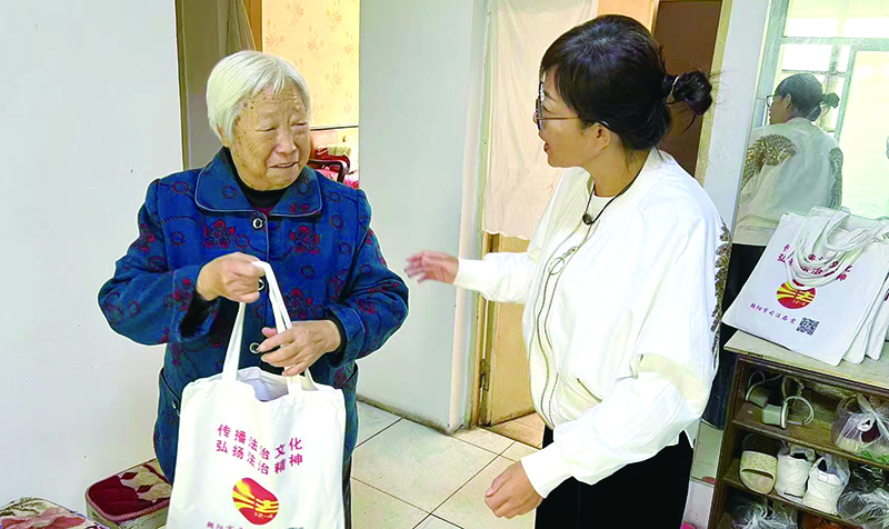 二题图，姜云丽（右）为社区老人送去反诈宣传册