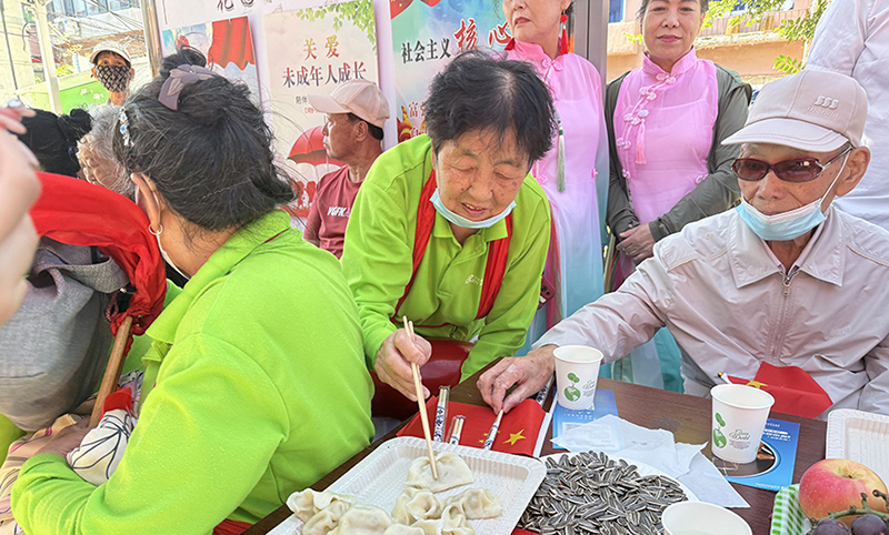 5图,志愿者为老人包饺子欢度节日
