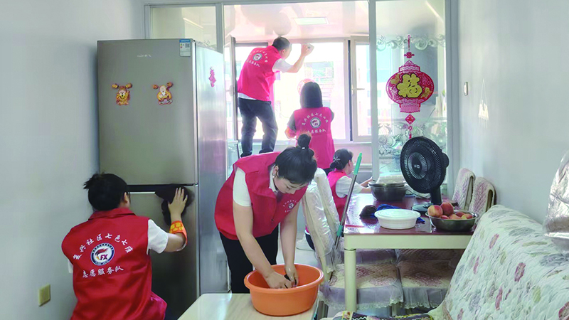 二题图,志愿服务队员为退伍老军人周德春打扫家庭卫生