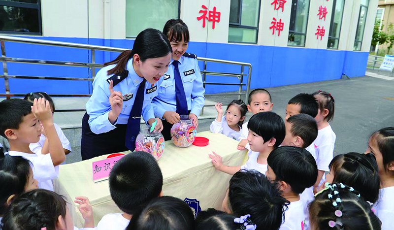 派出所警营开放活动上,民警正在向小朋友做防范知识问答