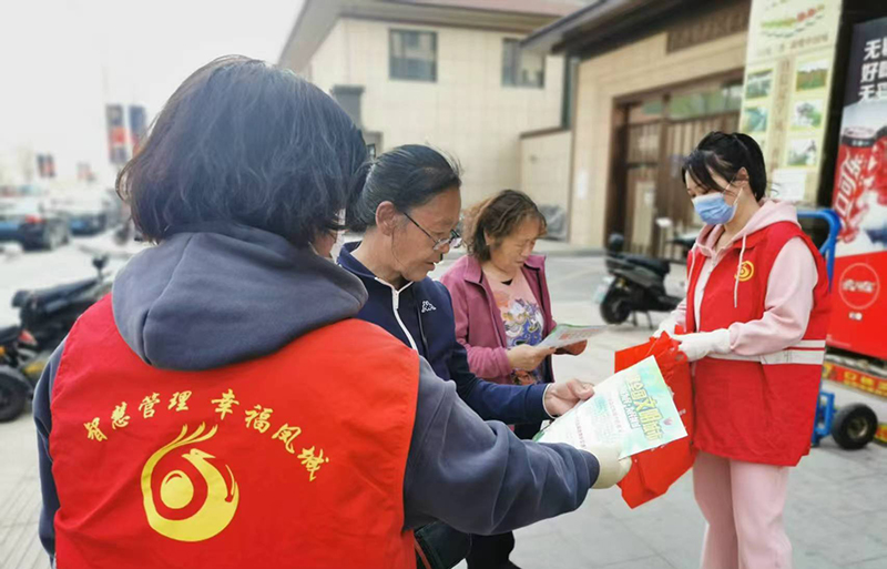 丹东图,志愿者向居民发放建设文明小区传单