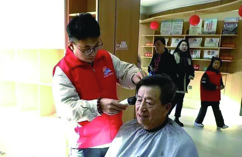 3美发师志愿者小王正在为独居老人张大爷理发。