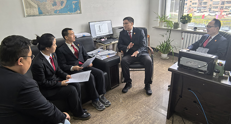 头题图,佟飞(右二)与执行干警研讨执行攻坚方案