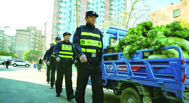 二题图，民警在秋菜售卖摊位集中区域开展巡逻