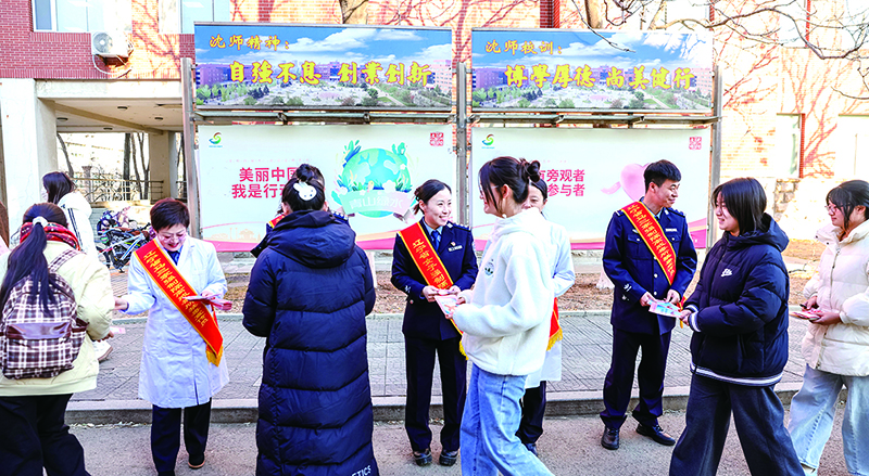 头题图，戒毒干警在沈阳师范大学校园发放宣传单。
