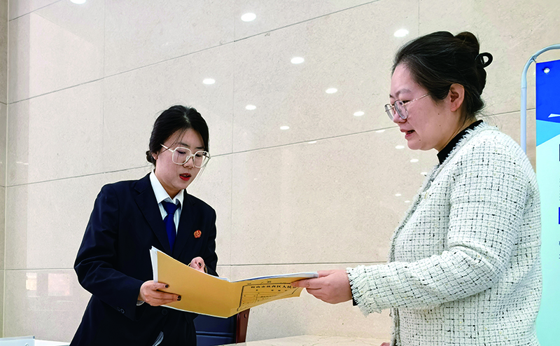 诉服中心的涉企案件绿色通道窗口,法官助理张嘉鑫正耐心指导当事人填写诉答文书