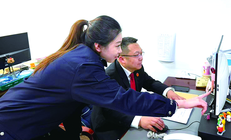 执行指挥中心副主任姜浩(右)指导执行局干警办案