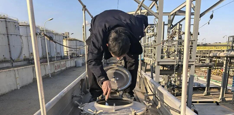 头题图,民警对涉案油罐车罐体进行勘察