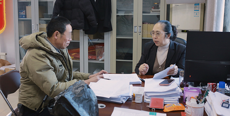 付菊（右）指导赵先生签调解协议（当事人打码）