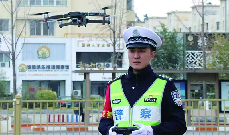 头题图,交警在执勤工作中准备使用“无人机”监控车流量。