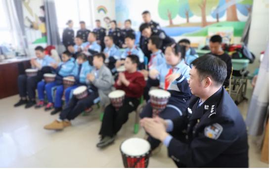 二题图，民警与孩子们一起拍打手鼓