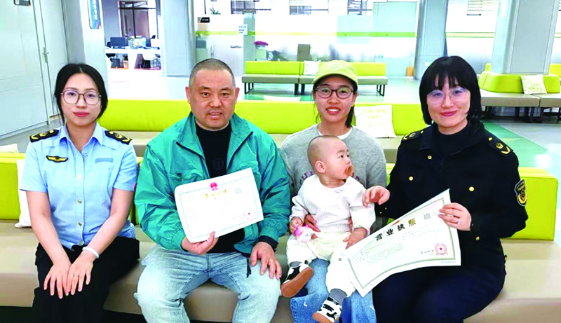 周烁（右）帮助某企业法定代表人顺利拿到营业执照