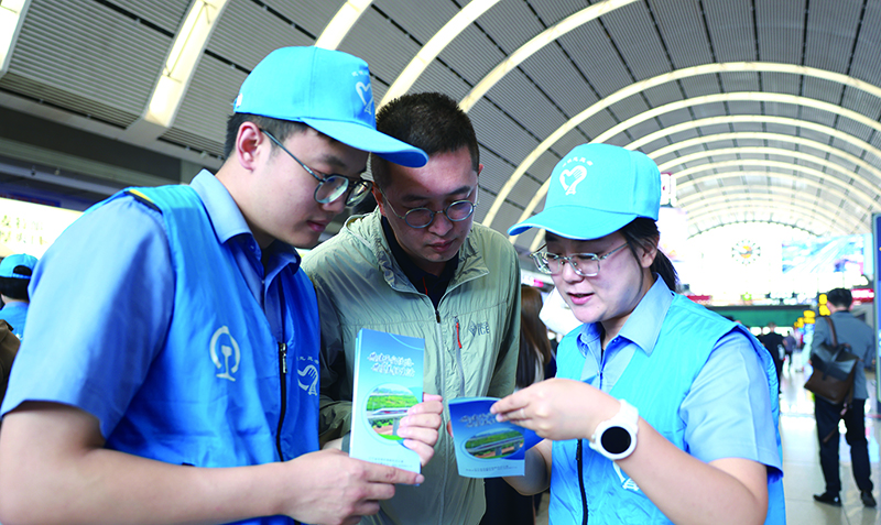 活动现场，志愿者正耐心地向铁路旅客普及铁路安全知识。 本报记者 孟浩 摄