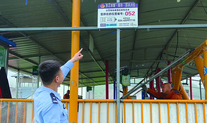 南芬派出所所长王忠智向记者介绍景区里的报警点位牌  本报记者刘妍 摄