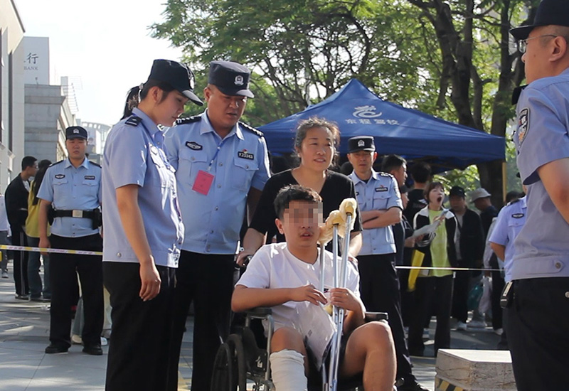 葫芦岛稿，民警护送考试进考场   张地 摄
