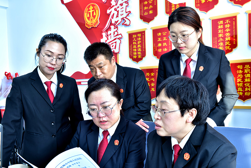赵威（前排左）日常带领庭内同志共同研究案件调解情况 （受访者供图）