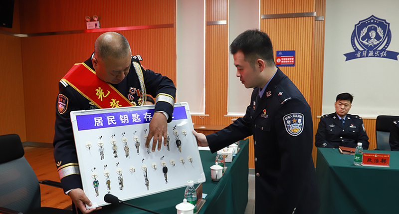 1老民警魏宝文在临退休之际将居民钥匙存放板传承给青年民警翟炜