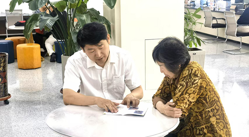 姜琦（左）耐心为受援人讲解法律援助相关法规。