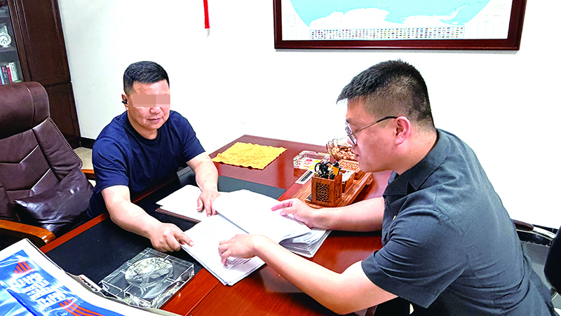 江海峰稿 执行法官(右)上门给申请执行人送达结案通知书(当事人打码)