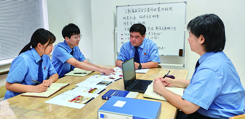 刘勇（右二）与干警们研究案情 受访单位供图