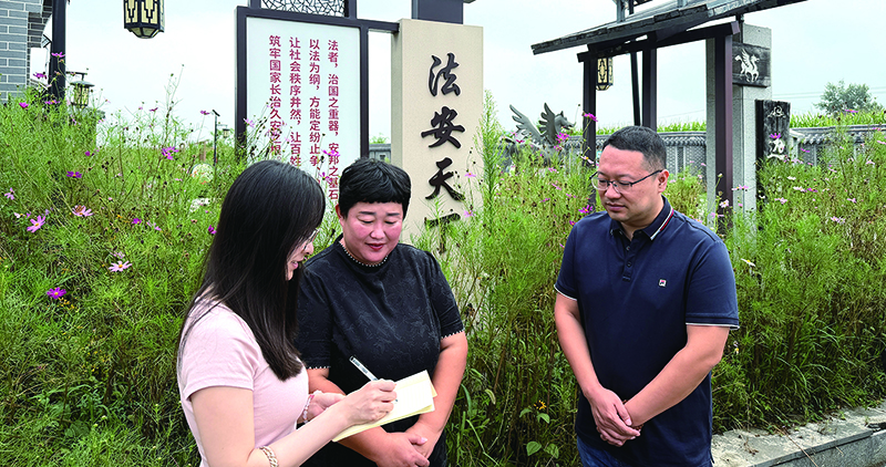 头题图，贾丹（中）在法治文化广场接受记者采访。本报记者栾岚 摄