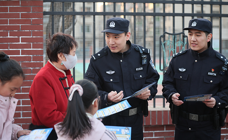 （09）2026年3月11日，放学时段，铁岭市公安局银州分局民警在银州区第十八小学护学岗执勤并发放反诈宣传单。作者：李松