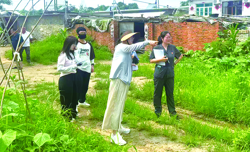 小刘与综治中心工作人员一同到村里勘察村落地
