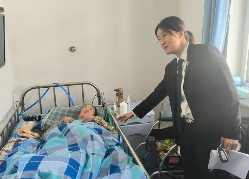 (老人的脸得打码!)3苏家屯区法院林盛法庭王菲法官在办案期间探望老人。